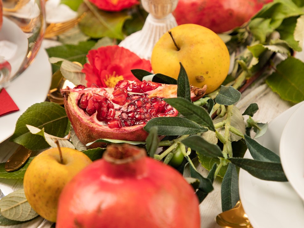 In der Mitte des Tisches befinden sich Früchte und Blätter als Dekoration In der Mitte des Tisches befinden sich Früchte und Blätter als Dekoration