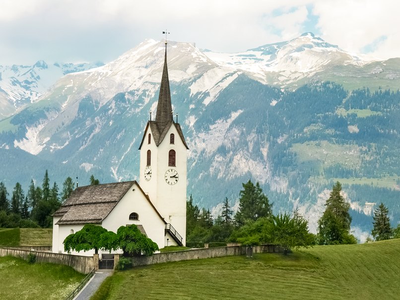 Eine Kirche vor einer Bergkulisse ist auch auf den Hochzeitsfotos beeindruckend
