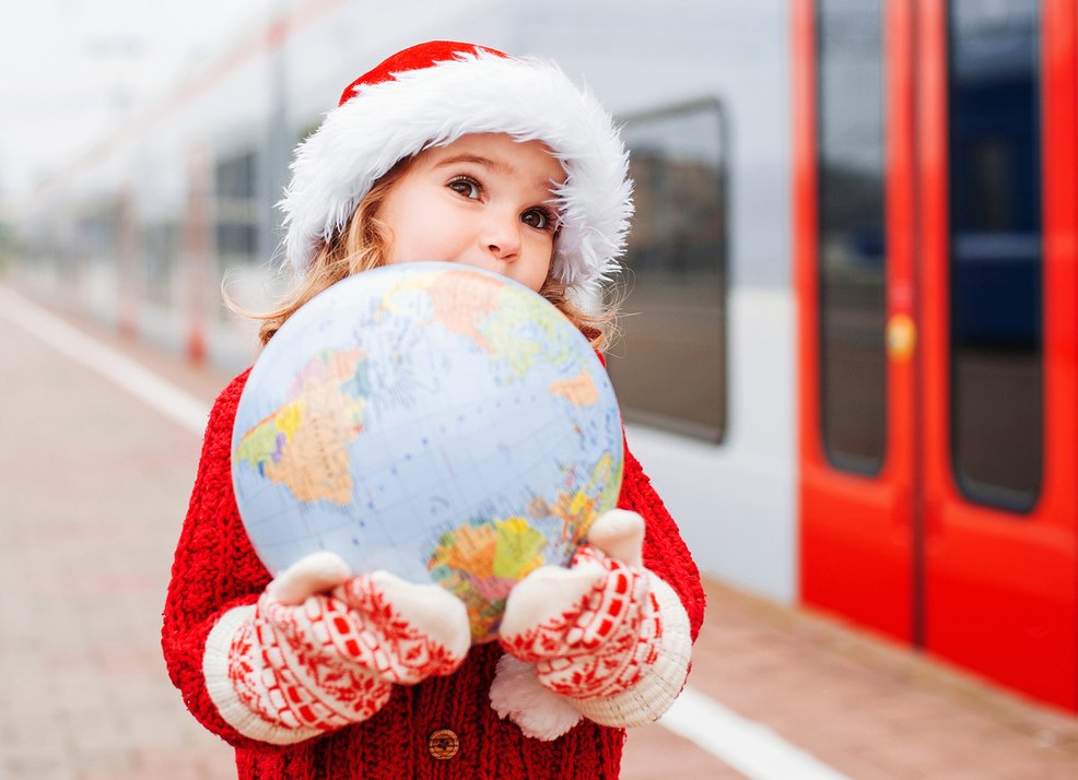 Kind mit Weihnachtsmütze und Globus
