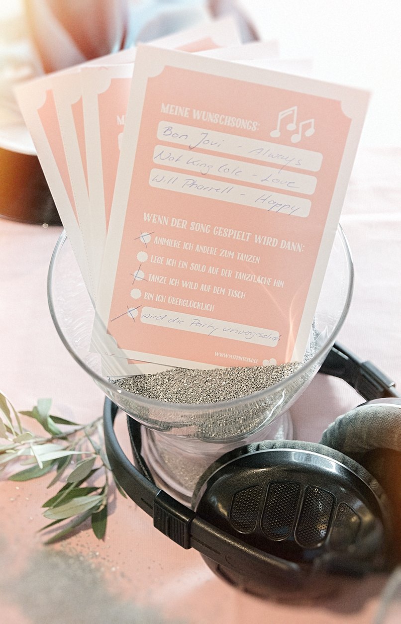 Glas mit Kopfhörer und Musikwunschzettel