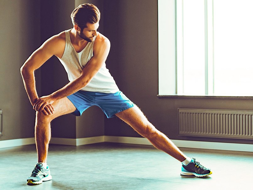 Mann wärmt sich mit Dehnübungen auf