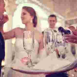Hochzeitspaar und Gäste genießen servierte Getränke