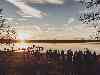 Hochzeitsgesellschaft bei Sonnenuntergang am See