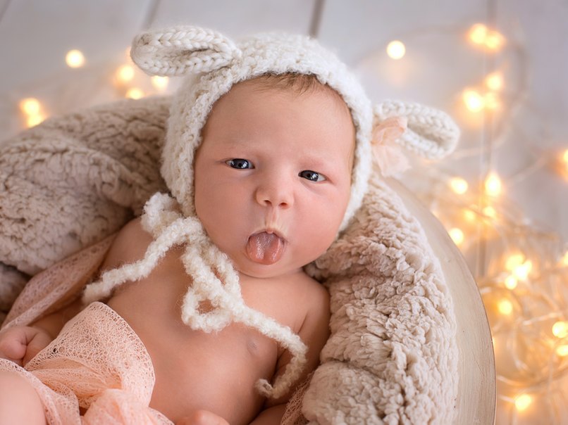 Neugeborenes streckt die Zunge heraus