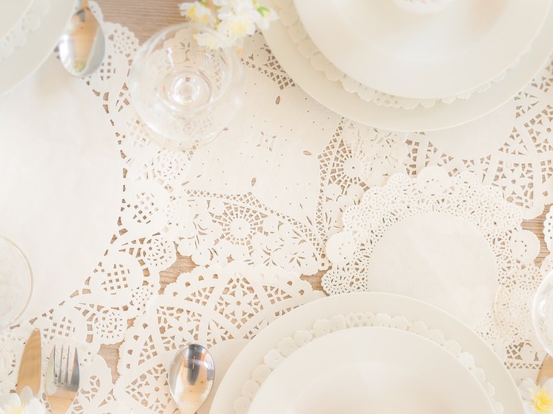 Ein Tischläufer aus Tortenspitze macht die Hochzeitsdeko zum Hingucker.
