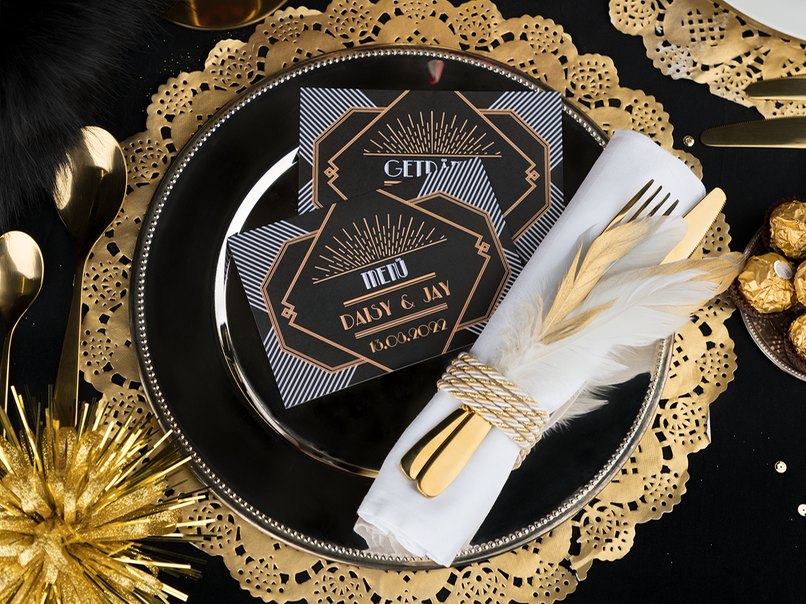 Ein glänzender Platzteller wertet die Tischdekoration in Schwarz und Gold auf. 